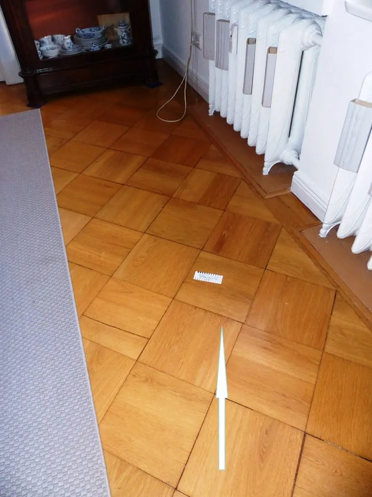 Graue Verfärbung auf Parkett neben der Heizung