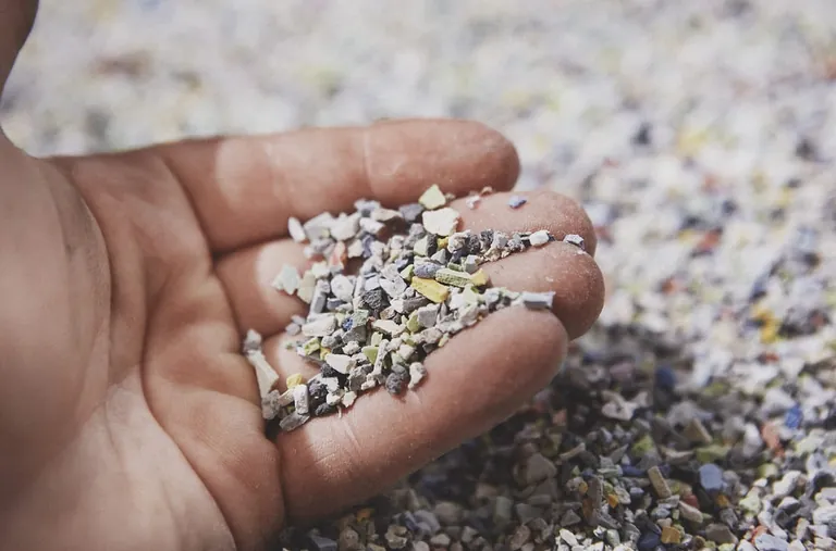 Hand mit Kieselsteinen - reichlich vorhandene Bestandteile für Materialien