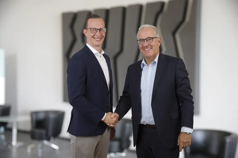 Ardex-Geschäftsführer Lukas Hädicke (27) und ehemaliger Geschäftsführer Dr. Ulrich Dahlhoff schütteln sich die Hand.