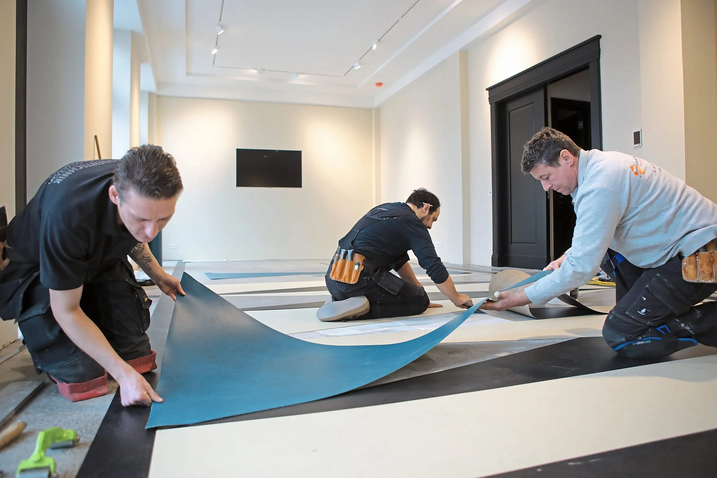 Zimmermann und Team verlegt Linoleum