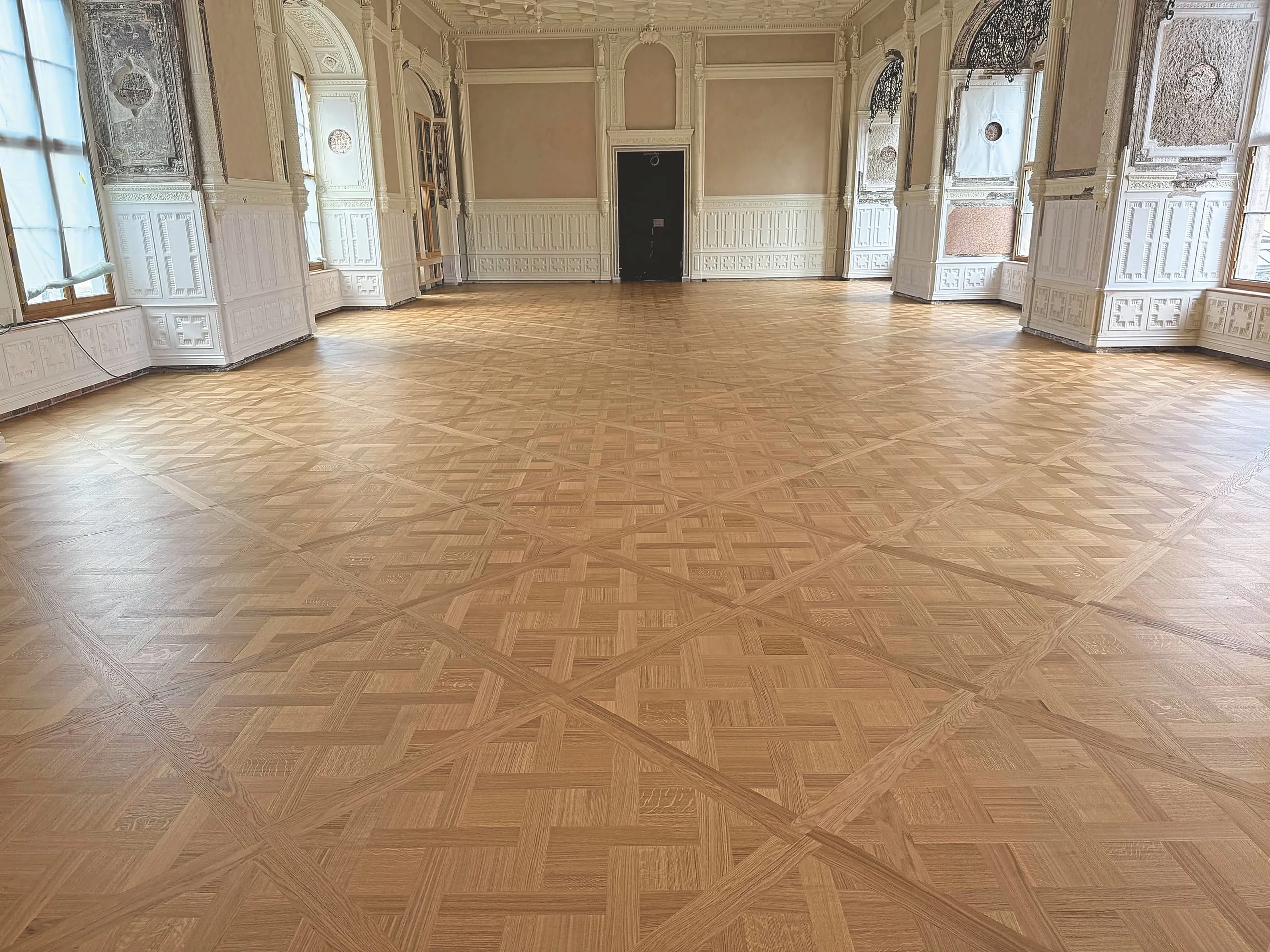 Der fertiggestellte Tafelparkettboden im großen Ballsaal zieht die Blicke auf sich.